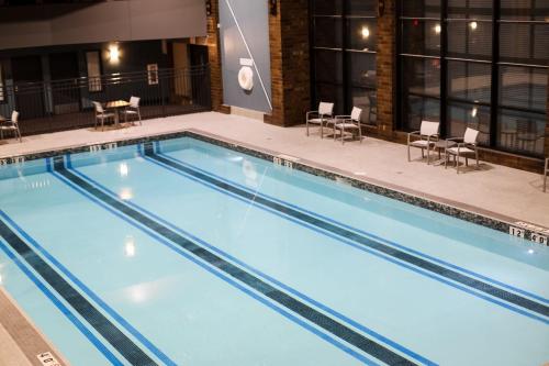 a large swimming pool with chairs and tables at Holiday Inn & Suites St. Cloud, an IHG Hotel in Saint Cloud