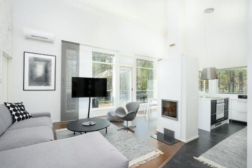 a white living room with a couch and a fireplace at Villa Tuomipakka in Kalajoki
