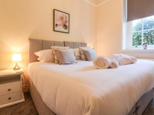 a bedroom with a large white bed with towels on it at The Cottage in Yarm