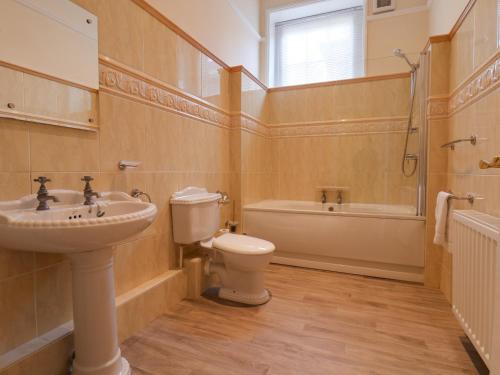 a bathroom with a sink and a toilet and a tub at The Cottage in Yarm