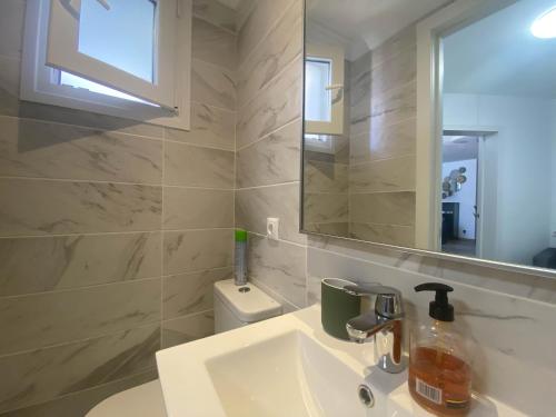 a bathroom with a sink and a mirror and a toilet at Nice Holiday Home - Sol Espanol in Sitio de Calahonda