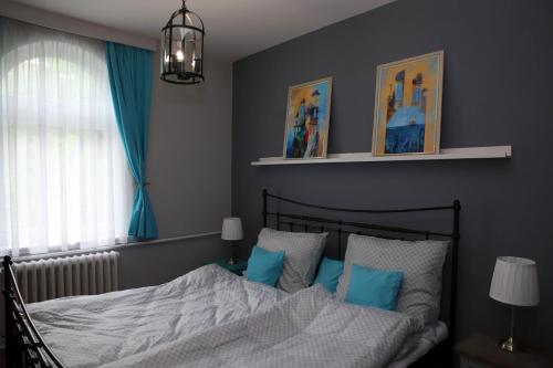 - une chambre avec un lit doté d'oreillers bleus et blancs dans l'établissement Rádi Apartman, à Eger