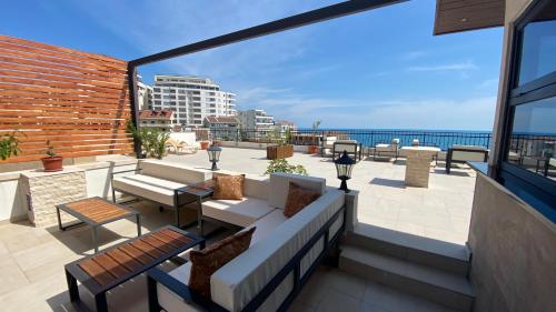 balcón con sofá y vistas al océano en Adriatic Apartments, en Ulcinj