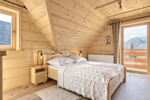 コシチェリスコにあるDomki Cepersko Ostoja w Kościeliskuの木造家屋内のベッドルーム(ベッド付)