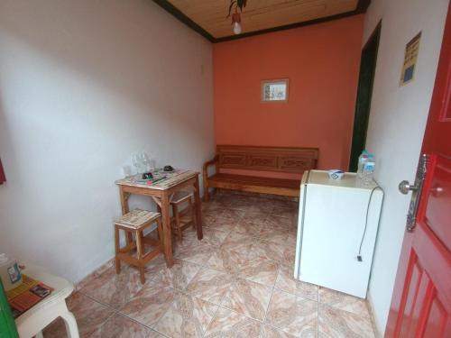 a kitchen with a small table and a refrigerator at Pouso Jequitibá in Tiradentes