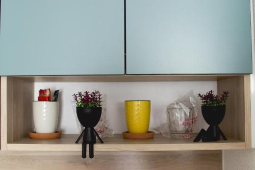 a shelf with three vases and a blue cabinet at Apartments HAN 2 Sarajevo in Sarajevo