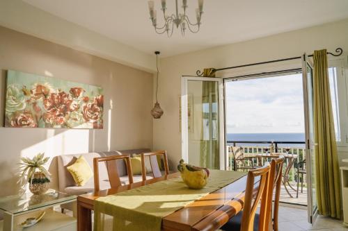 een eetkamer met een tafel en uitzicht op de oceaan bij Drita Studios & Apartments in Svoronata