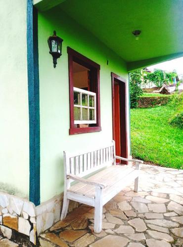 a bench sitting on the side of a house at Pouso Jequitibá in Tiradentes