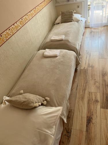 uma fila de camas num quarto com pisos em madeira em Mikszáth Apartman em Balatonfüred