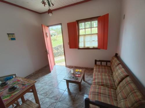 ein Wohnzimmer mit einem Sofa und einem Tisch in der Unterkunft Pouso Jequitibá in Tiradentes