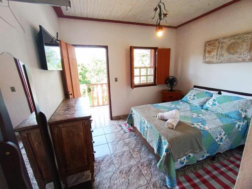 ein Schlafzimmer mit einem Bett in einem Zimmer in der Unterkunft Pouso Jequitibá in Tiradentes