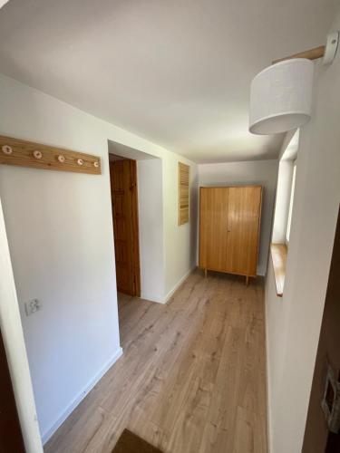 an empty living room with wood floors and a hallway at Kisielkowo in Wilkasy