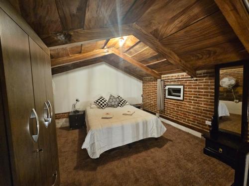 sypialnia z łóżkiem i ceglaną ścianą w obiekcie Hot Chipilin w mieście Antigua Guatemala