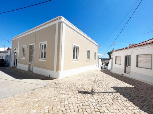 un edificio blanco en una calle adoquinada en Guesthouse Casa Felicia, en Montes de Alvor