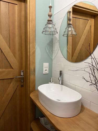 a bathroom with a white sink and a mirror at WYWIAŁOWO in Olsztyn