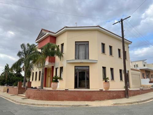 a yellow house with palm trees in front of it at Palm Villa Private Studio in Phrenaros