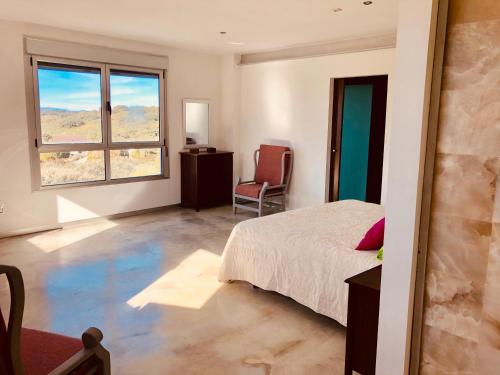 a bedroom with a bed and a window at VILLA LA DUQUESA 