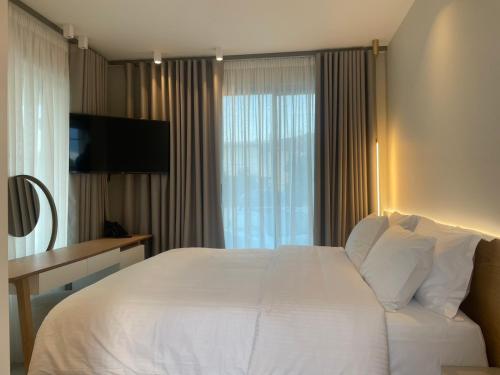 a hotel room with a white bed and a window at Balance Accommodation in Stavros