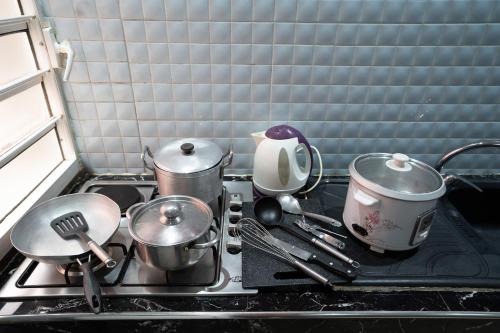 una estufa de cocina con ollas y sartenes en Aparthotel Madeleine, en Antananarivo