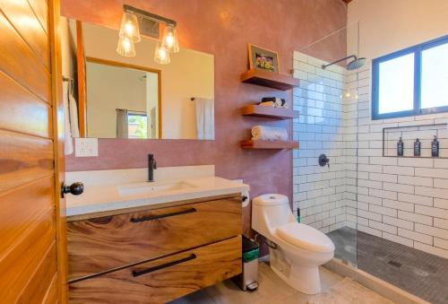 bagno con lavandino, servizi igienici e specchio di La Joya de Nosara a Playa Pelada