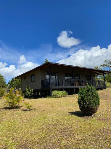 a large house with a large porch and balcony at Maunga Roa Eco Lodge in Hanga Roa