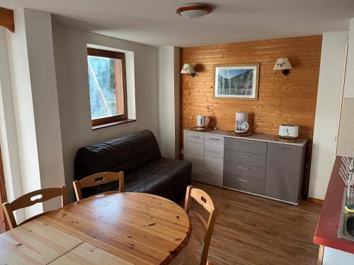 a living room with a black couch and a table at Chamrousse Appart 8 personnes au pied des pistes in Chamrousse