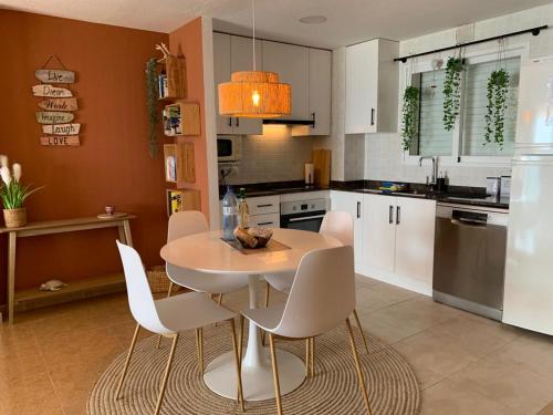 a kitchen with a white table and white chairs at Seaview in Villajoyosa