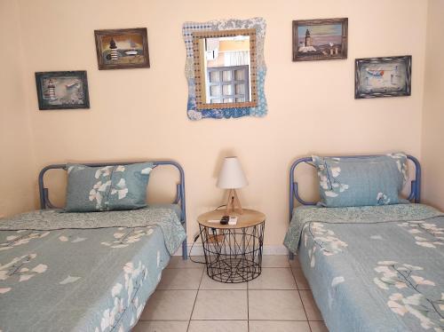 a bedroom with two beds and a mirror on the wall at Casa Stella in Agia Triada