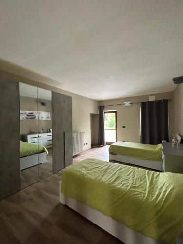 - une chambre avec 2 lits et un miroir dans l'établissement Beinalot Country House, à Bene Vagienna