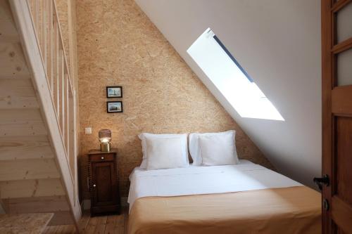 a bedroom with a bed with a sloped ceiling at Villa Bérylune in Ostend