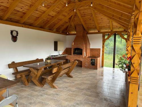a living room with a table and a fireplace at Liniștea Muntilor Cartioasra in Cîrţişoara