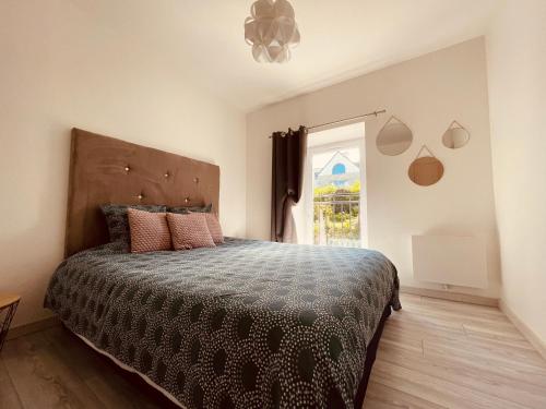 ein Schlafzimmer mit einem großen Bett und einem Fenster in der Unterkunft Sur le chemin de la plage in Cherbourg en Cotentin