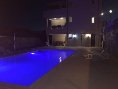een zwembad 's nachts met blauwe verlichting bij Zimmer mit Bad Imotski in Imotski