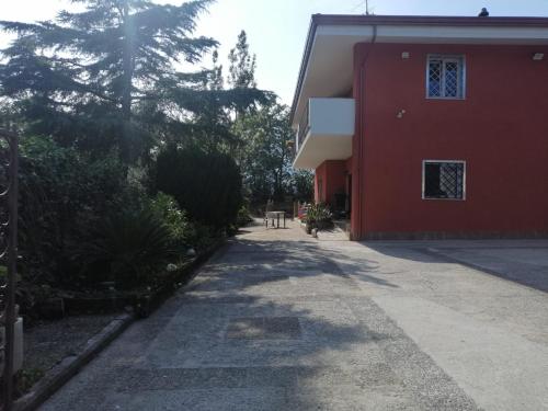 um edifício vermelho com um passeio ao lado de um edifício em Villa Montemma em Montesarchio