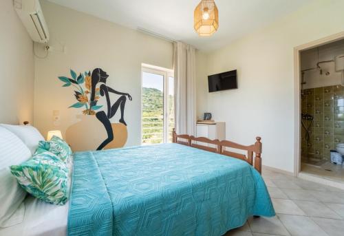 a bedroom with a bed with a blue bedspread at Drita Studios & Apartments in Svoronata