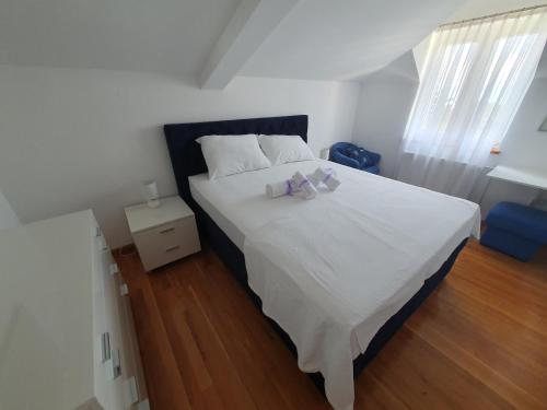 una camera da letto con un letto bianco con due peluche sopra di Villa Red Rose a Njivice