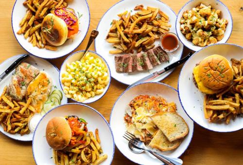 a table topped with plates of food and french fries at Holiday Inn Chicago O'Hare - Rosemont by IHG in Rosemont