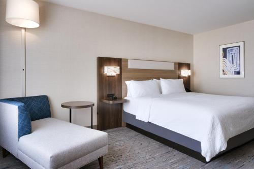 a hotel room with a bed and a chair at Holiday Inn Express and Suites Helena by IHG in Helena
