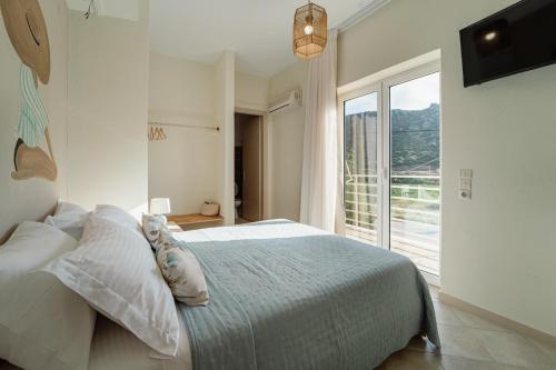 a bedroom with a bed and a large window at Drita Studios & Apartments in Svoronata