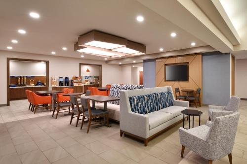 a waiting room with a couch and tables and chairs at Holiday Inn Express and Suites Helena, an IHG Hotel in Helena