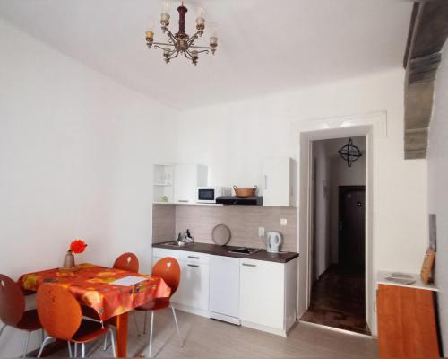 cocina con mesa, sillas y lámpara de araña en Old city center, en Rijeka