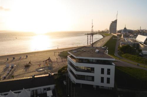 vista su una spiaggia e su un edificio e sull'oceano di Bheaven I Marina Premium Apartment a Bremerhaven