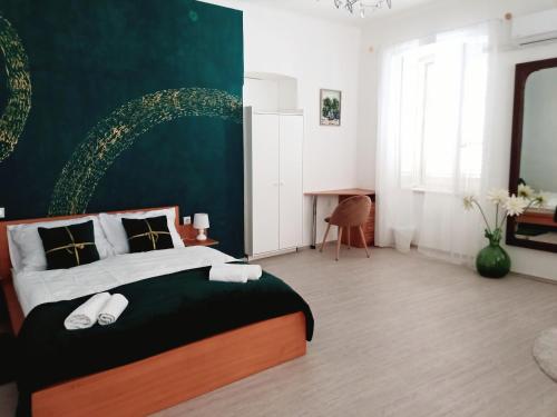Un dormitorio con una cama grande con una pared verde. en Old city center, en Rijeka