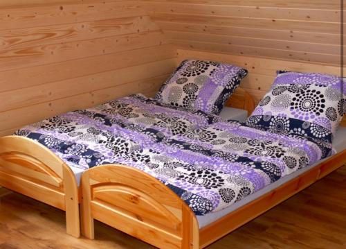a wooden bed with pillows on top of it at Domki na Tynioku in Koniaków