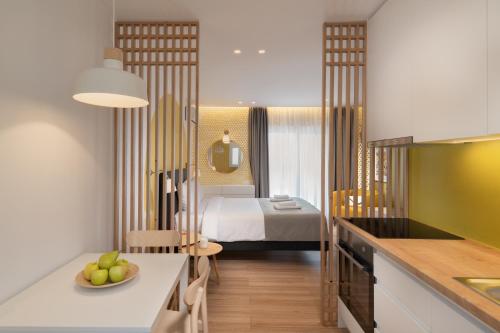 een kamer met een keuken en een slaapkamer met een bed bij Citrus Home- Στούντιο με θέα στο κέντρο της πόλης in Agios Nikolaos