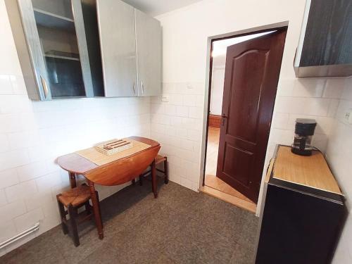 a small kitchen with a wooden table and a door at Private House with Garden in Mislea