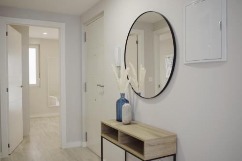 a bathroom with a mirror and a vase on a table at JOMAR Apartamento en Coruña in A Coruña