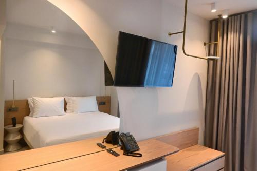 a bedroom with a bed and a tv on the wall at Balance Accommodation in Stavros