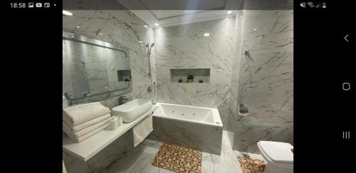 a white bathroom with a tub and a sink at Tanger cente ville in Tangier