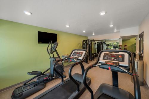 a gym with three treadmills in a room at WoodSpring Suites West Palm Beach in West Palm Beach